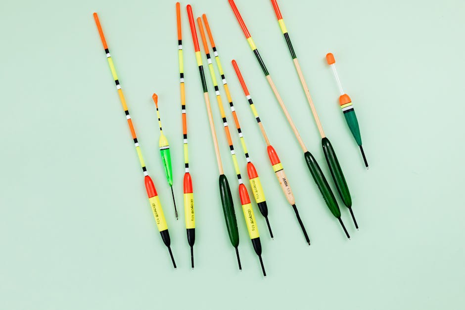 Vibrant fishing floats arranged on a pastel green background in a flat lay style.